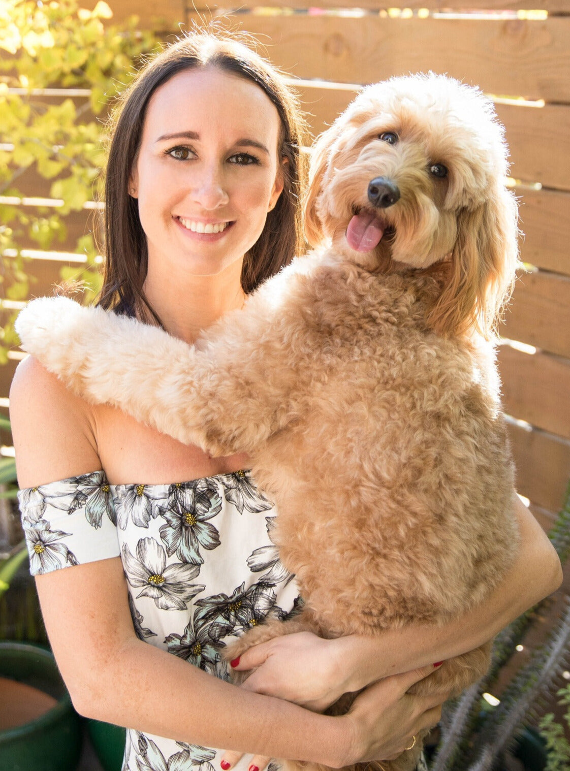 Owner, Kelsey, posing with her pet golden doodle, Bodhi