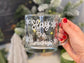 christmas coffee mug, fun christmas cup with Slay the Holidays in white cursive and white snowflakes around the cup, l13oz clear glass cup, christmas decor background