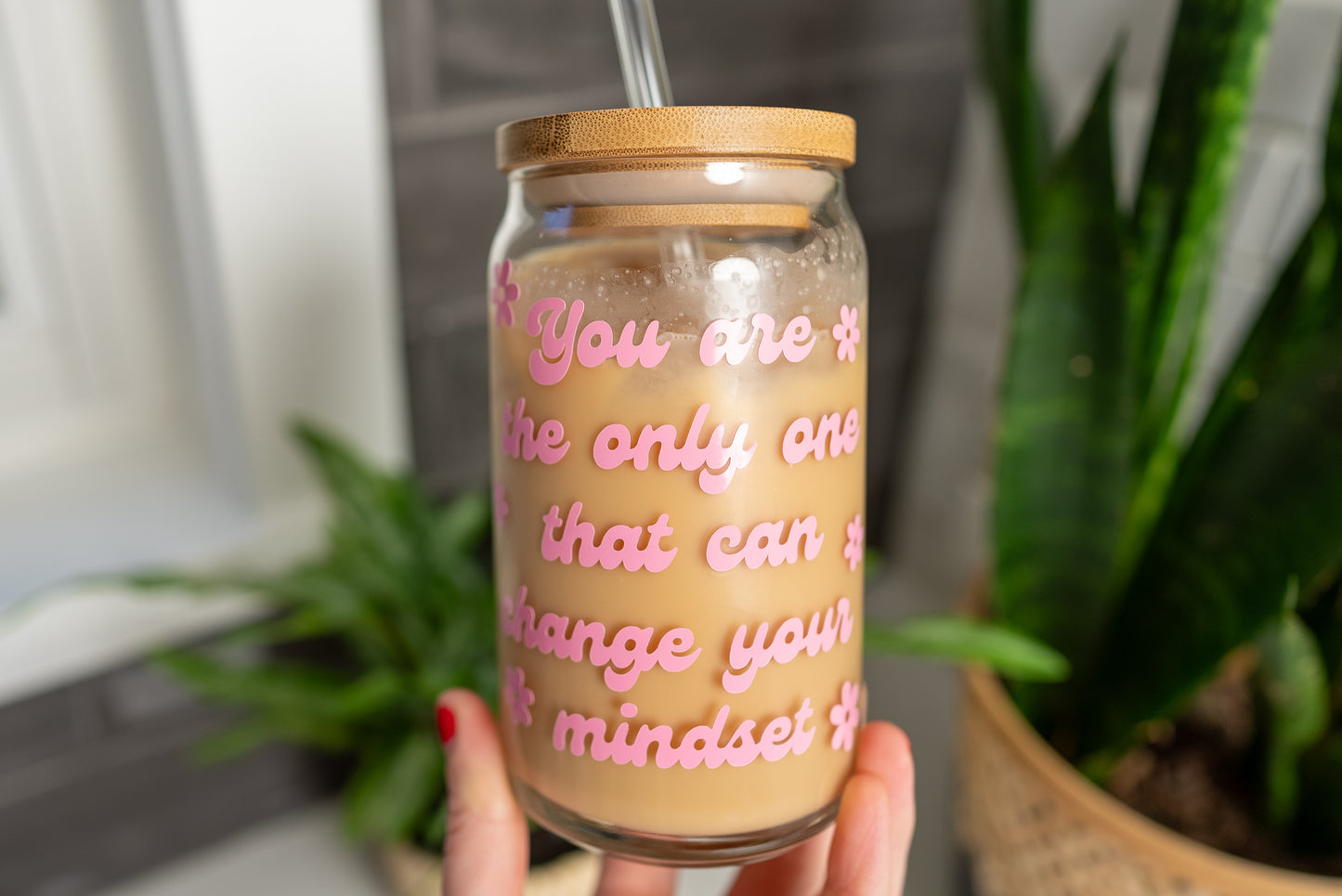 You are the only one that can change your mindset quote on a glass cup with a retro style font in pink with daisy flowers around it, 16oz beer can glass filled with iced coffee, positive mindset cup