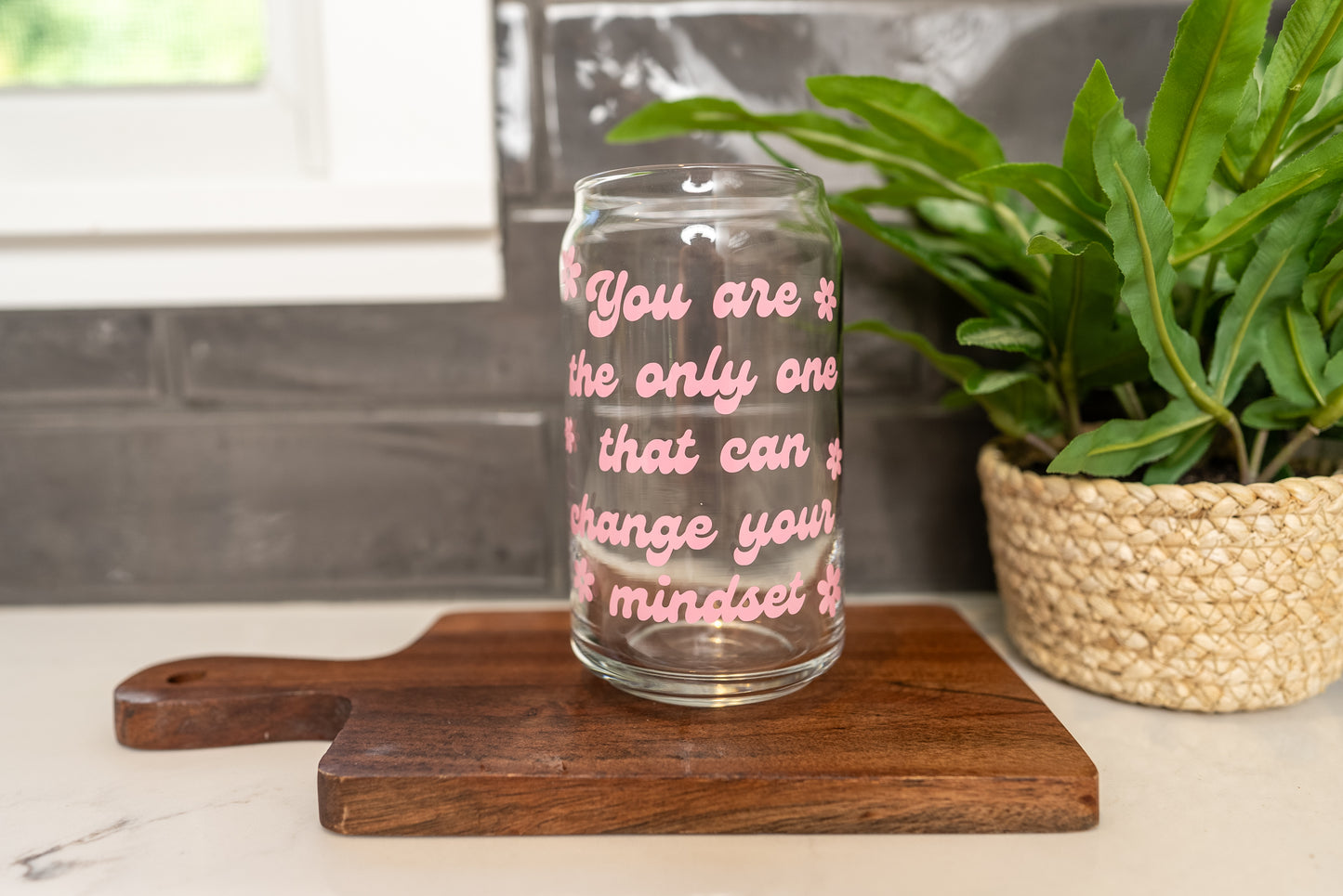 Positivity Cup with 'You are the only one that can change your mindset' quote on a clear glass cup with a retro style font in pink with daisy flowers around it, 16oz iced coffee cup, positive mindset cup