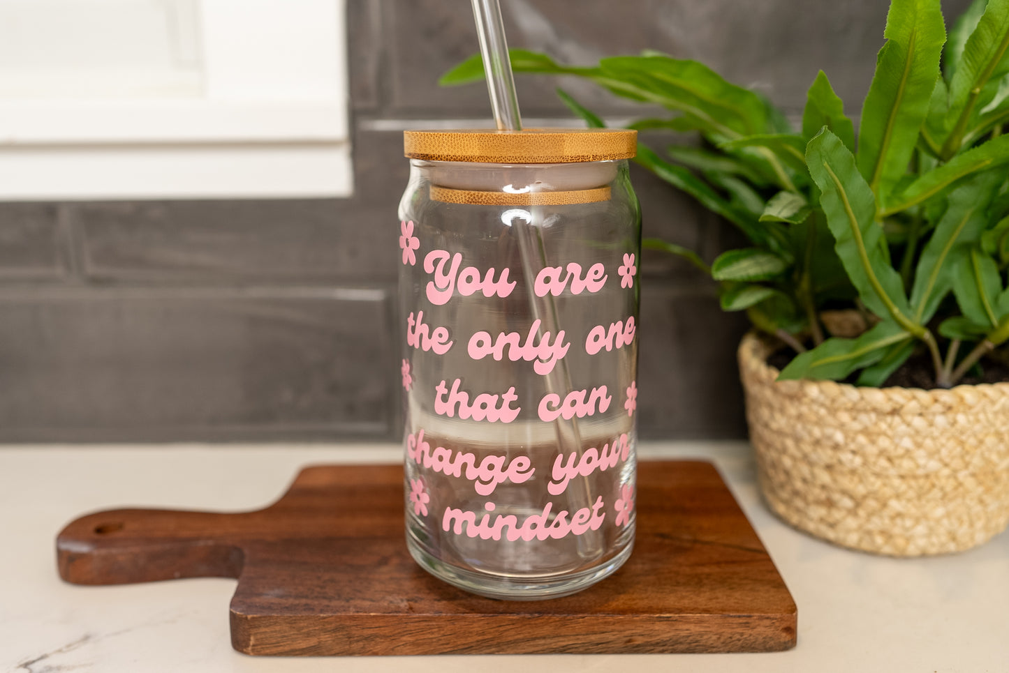 You are the only one that can change your mindset quote on a glass cup with a retro style font in pink with daisy flowers around it, 16oz iced coffee cup, positive mindset cup